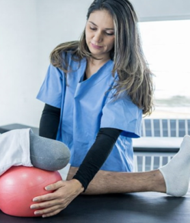 Physical therapist assisting a below-knee amputee with prosthetic rehabilitation exercises to improve strength, balance, and prosthetic success